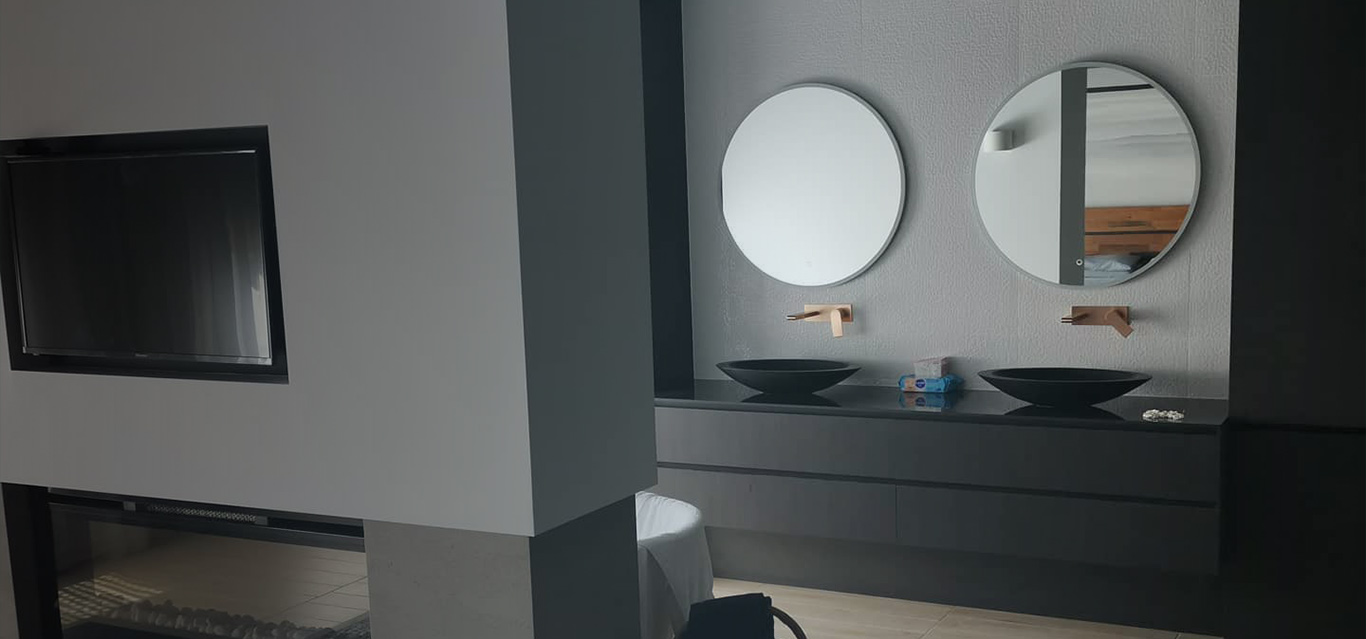 a modern, minimalist bathroom design featuring a dark-toned double vanity